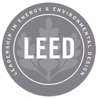 Insignia LEED de Liderazgo en Energía y Diseño Ambiental con una hoja de roble de fondo.