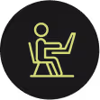 Icono de una persona sentada trabajando en una computadora portátil.