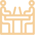 Icono estilizado de un espacio de coworking con mesas, sillas y una planta.